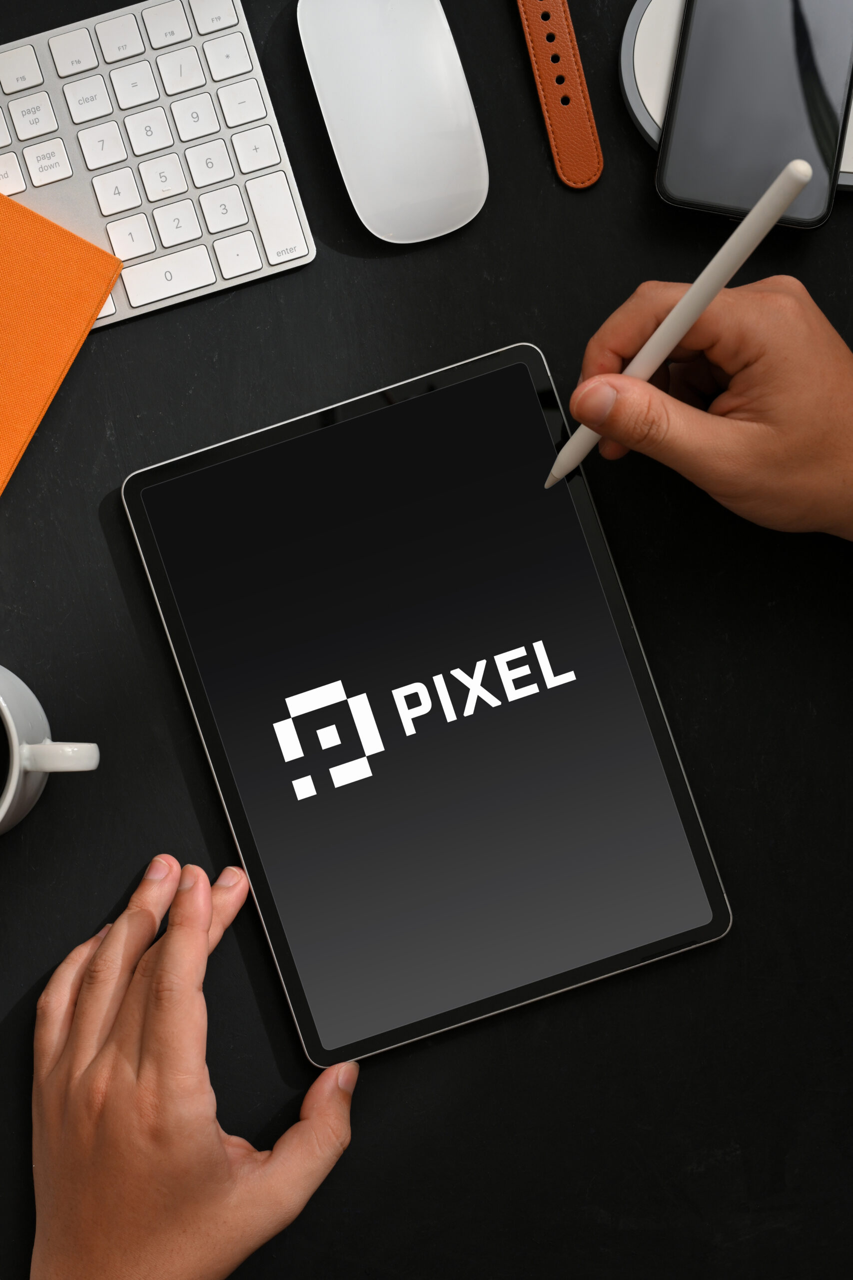 Top view of male hand using digital tablet on creative workspace with accessories and supplies, clipping path